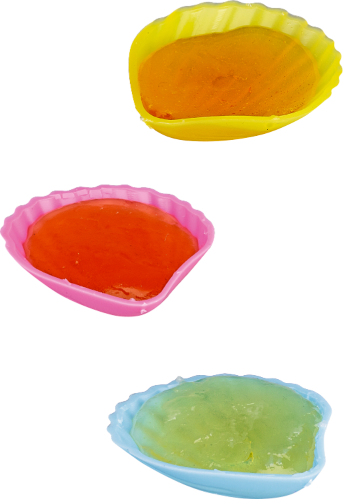 Drei muschelförmige Formen in Gelb, Rot und Blau mit bunter Bonbonmasse.