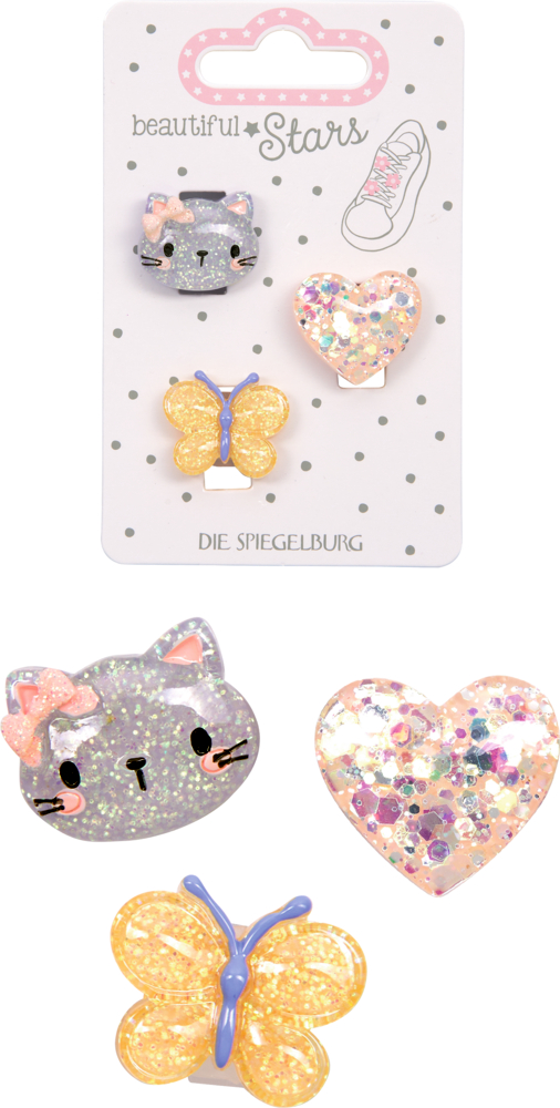 Drei glitzernde Sneaker Charms in Form von Katzenkopf, Herz und Schmetterling, dahinter noch mal die Verpackteansicht auf Karte mit Punktmuster.