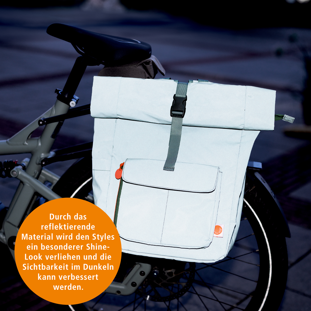 Hell-reflektierende Fahrradtasche mit Fronttasche und Steckverschluss, befestigt am Gepäckträger eines Fahrrads.