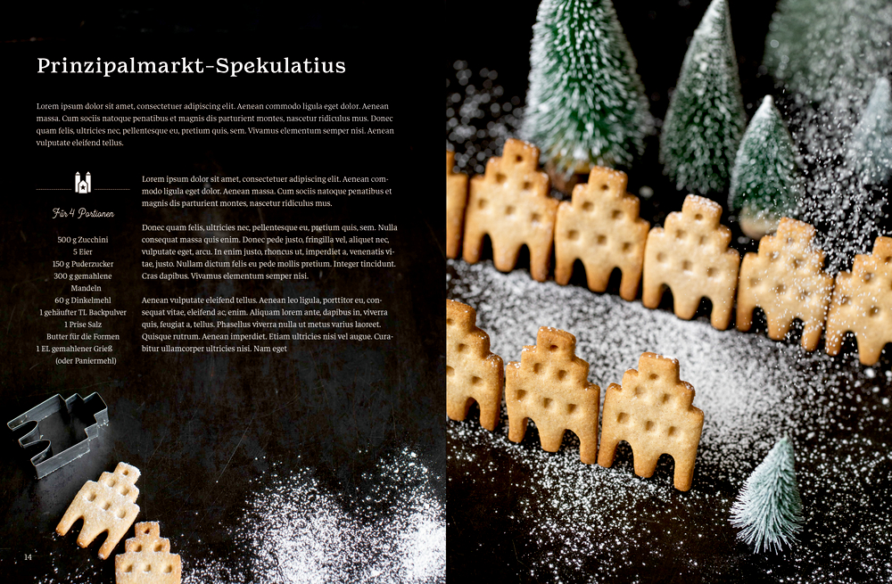 Mit Puderzucker bestäubte Kekse, angeordnet zwischen kleinen Kiefernbäumen auf dunklem Hintergrund.