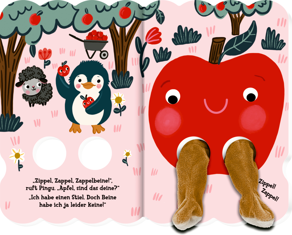 Ein Pinguin hält Äpfel neben einem großen roten Apfel mit Stoff-Beinen. Im Hintergrund steht ein Schaf neben Apfelbäumen.