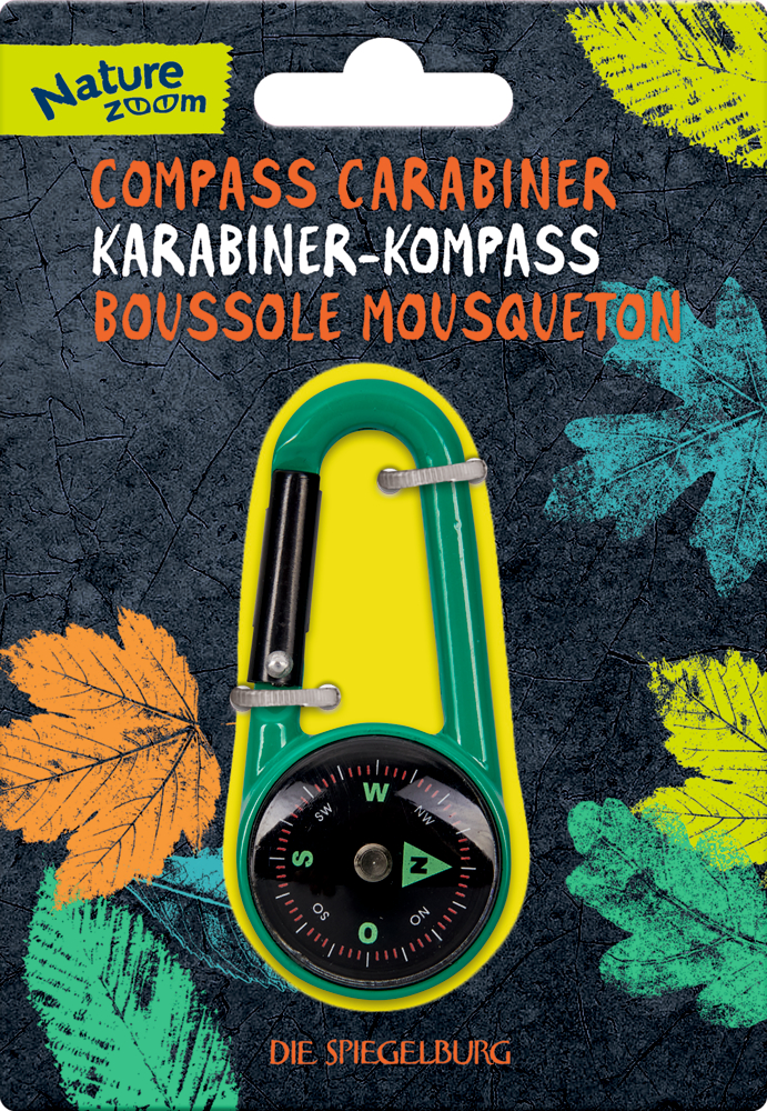 Grüner Karabiner mit integriertem Kompass auf einer Pappkarte mit Blättermuster.