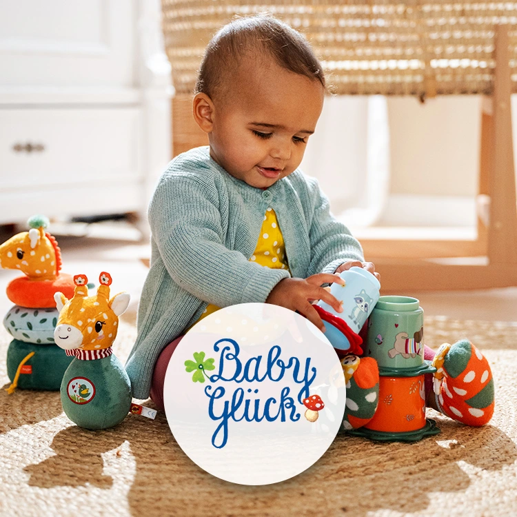 Baby mit Spielsachen auf einem cremefarbenen Juteteppich.