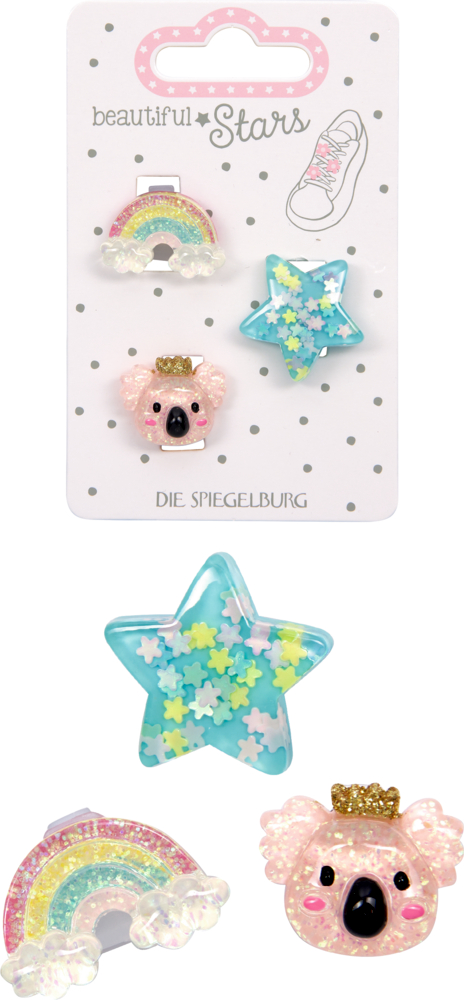 Drei glitzernde Sneaker Charms in Form von Regenbogen, türkisener Stern und rosa Koalakopf mit goldener Krone, dahinter noch mal die Verpackteansicht, auf Karton mit Punkten.