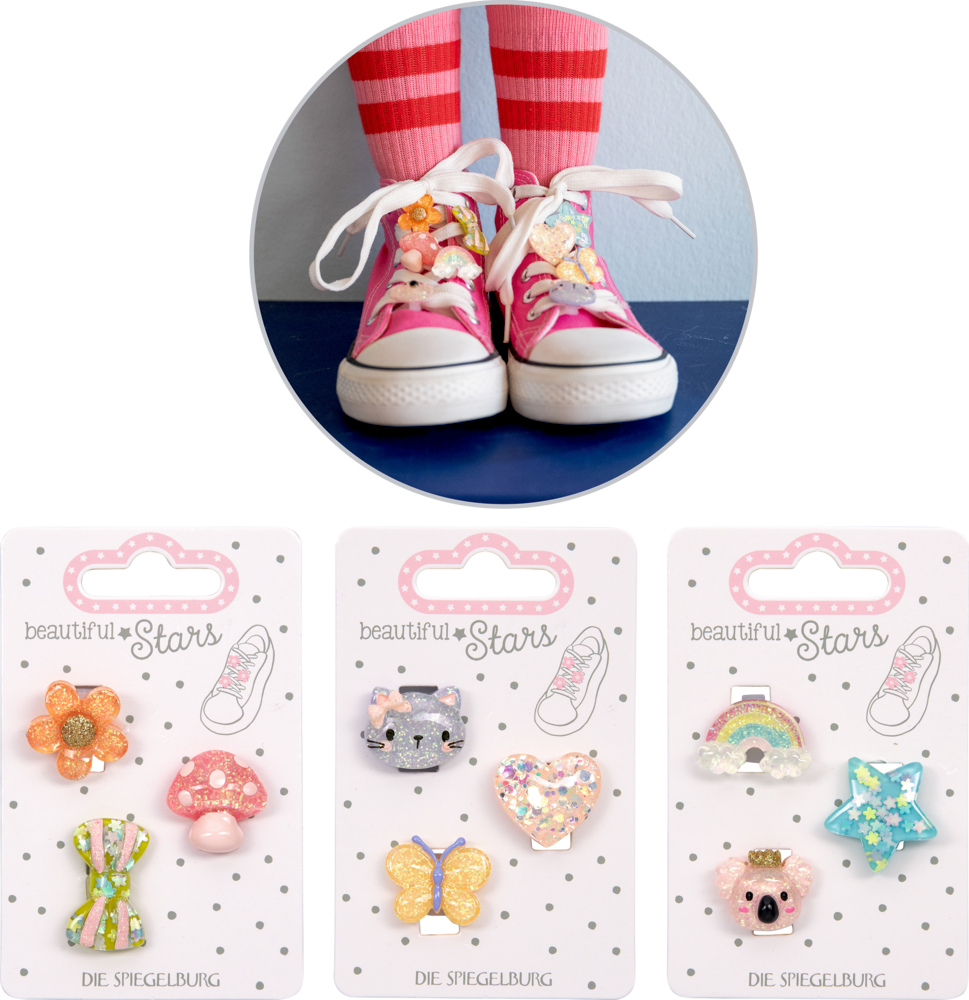 Drei Sets bunter Sneaker Charms in Tier-, Blumen- und Sternformen sowie rosa Sneakers mit dekorierten Schnürsenkeln.