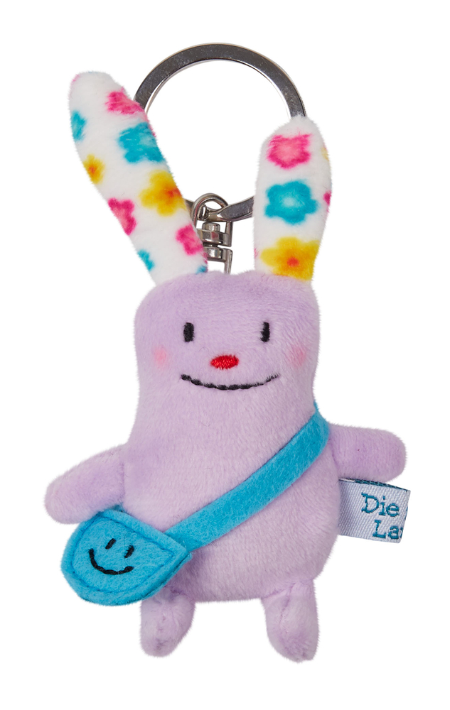 Lila Plüschfigur-Schlüsselanhänger mit bunten Ohren, blauer Tasche und einem lächelnden Gesicht.