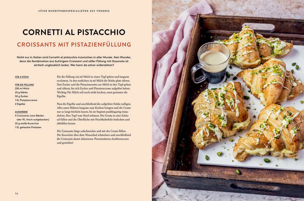 Vier Croissants mit Pistazienfüllung und gehackten Pistazien auf einem Tablett, daneben eine Tasse Kaffee.