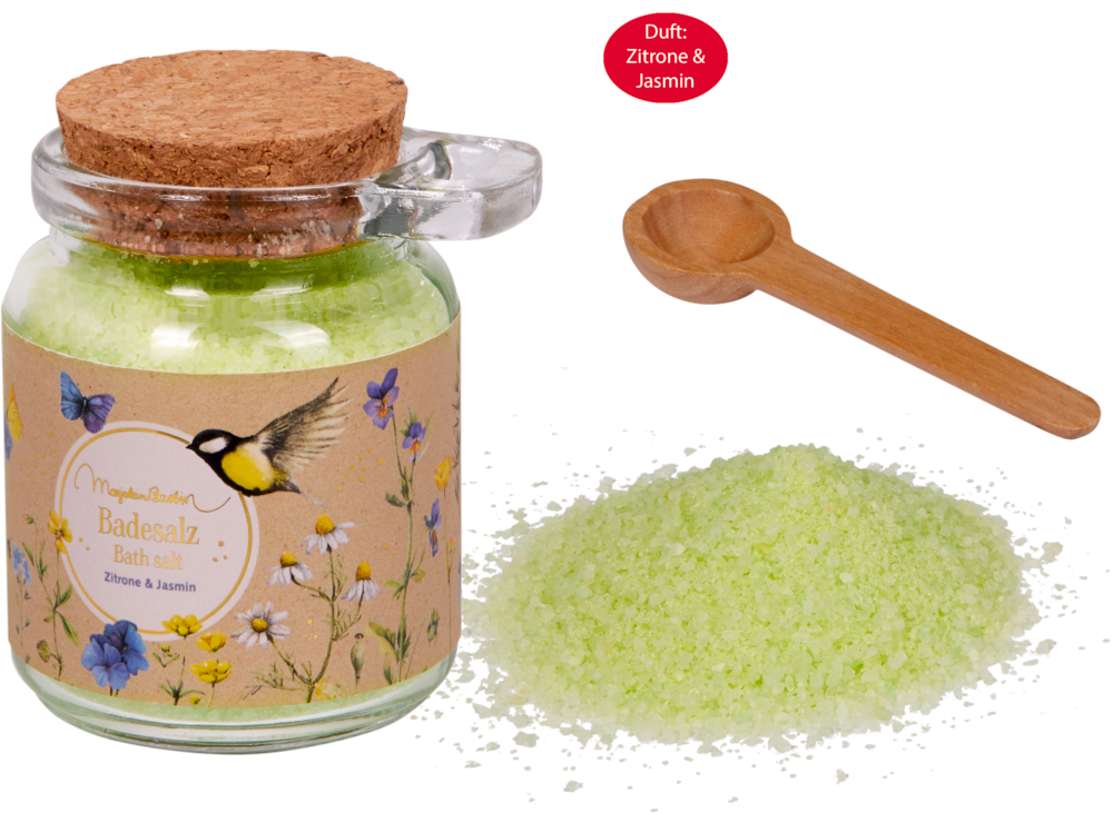Glas mit grünem Badesalz, Korkdeckel, Holzlöffel und Etikett mit Blumen und einem Vogel.