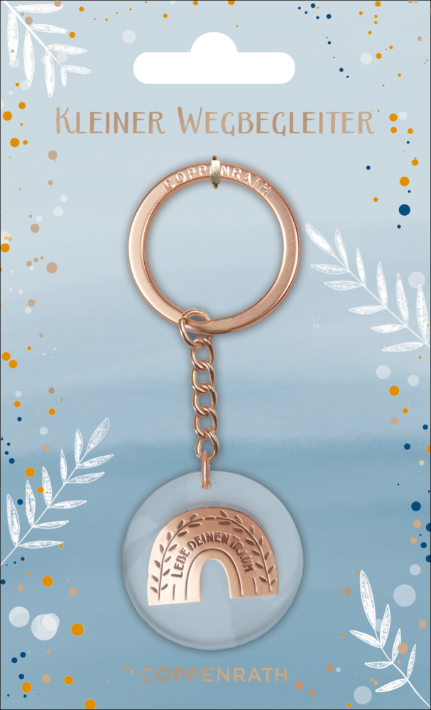 Roségoldener Schlüsselanhänger mit Regenbogenanhänger auf einer blauen Karte mit der Aufschrift „Kleiner Wegbegleiter“.