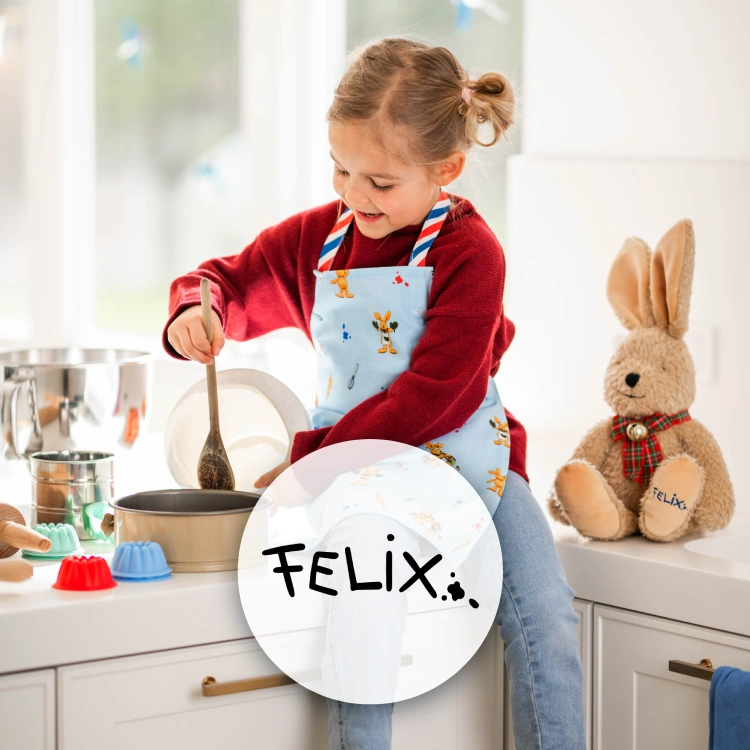 Mädchen mit Schürze sitzt auf einer Küchenzeile und rührt in einem Teig. Daneben ein Plüschhase sowie das Logo der Marke "Felix".