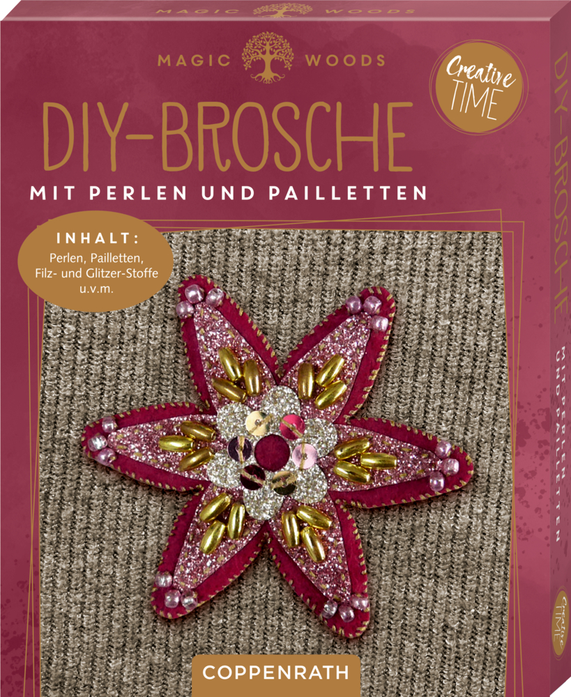 DIY-Broschenset mit Perlen und Pailletten in Blütenform auf grauem Stoff, rosa-goldene Verpackung.