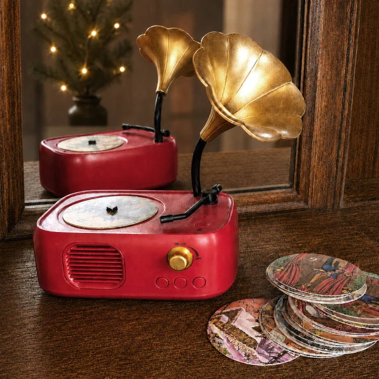 Kleines Grammophon und Schallplatten in einem alten Regal mit Spiegelfläche dahinter.