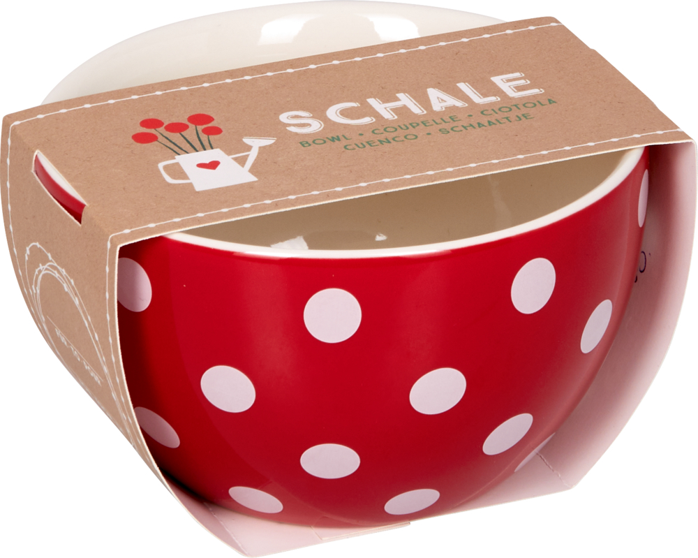 Rote Schüssel mit weißen Punkten in einer braunen Papphülle mit der Aufschrift „SCHALE“ und der Grafik einer Gießkanne.