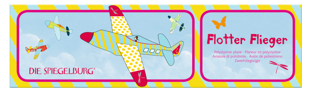 Vier bunte Spielzeugflugzeuge mit blauem Himmel und Text auf einer länglichen Papierverpackung mit gelb-roter Umrandung. .
