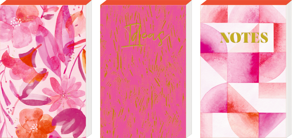 Drei rosafarbene Notizbüchern mit floralen, goldenen „Ideas“- und goldenen „Notes“-Motiven auf den Umschlägen.