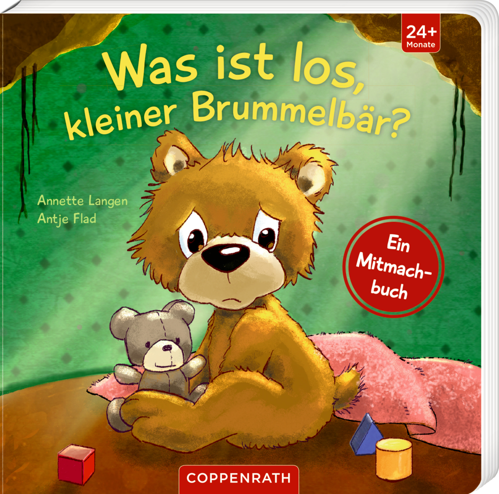 Auf dem Cover von "Was ist los kleiner Brummbär?" ist ein trauriger Bär der einen einen Teddy umarmt, während er mit Spielzeug auf dem Boden sitzt, abgebildet.